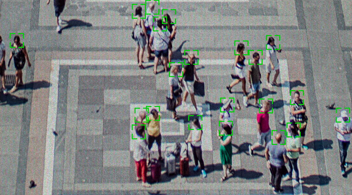 Viele Menschen auf einem öffentlichen Platz werden von einer Videokamera überwacht.