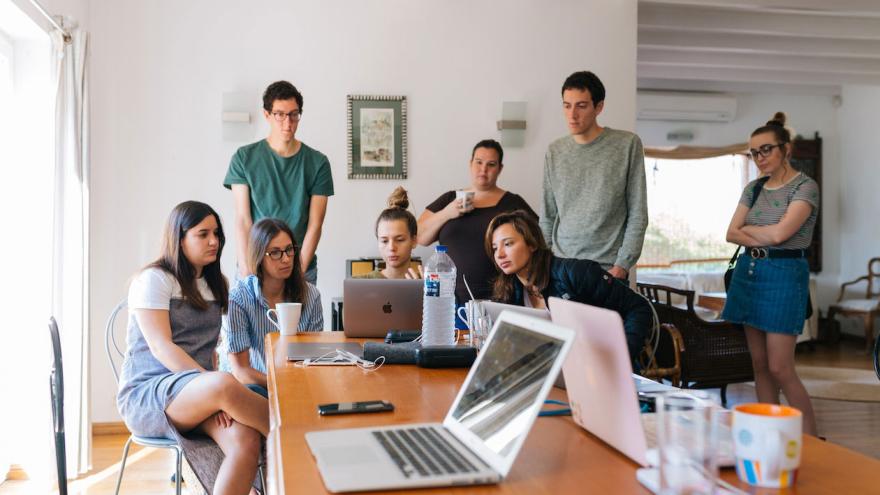 Eine Gruppe Menschen in einem Büro betrachtet kritisch Informationen auf einem Laptop 