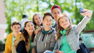 Eine Gruppe fröhlicher Jugendlicher nimmt ein Selfie auf